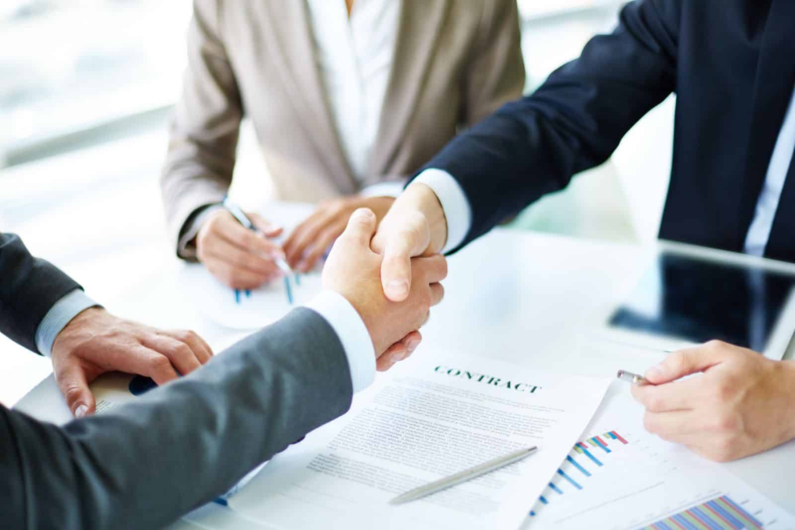 Business people shaking hands over a signed contract